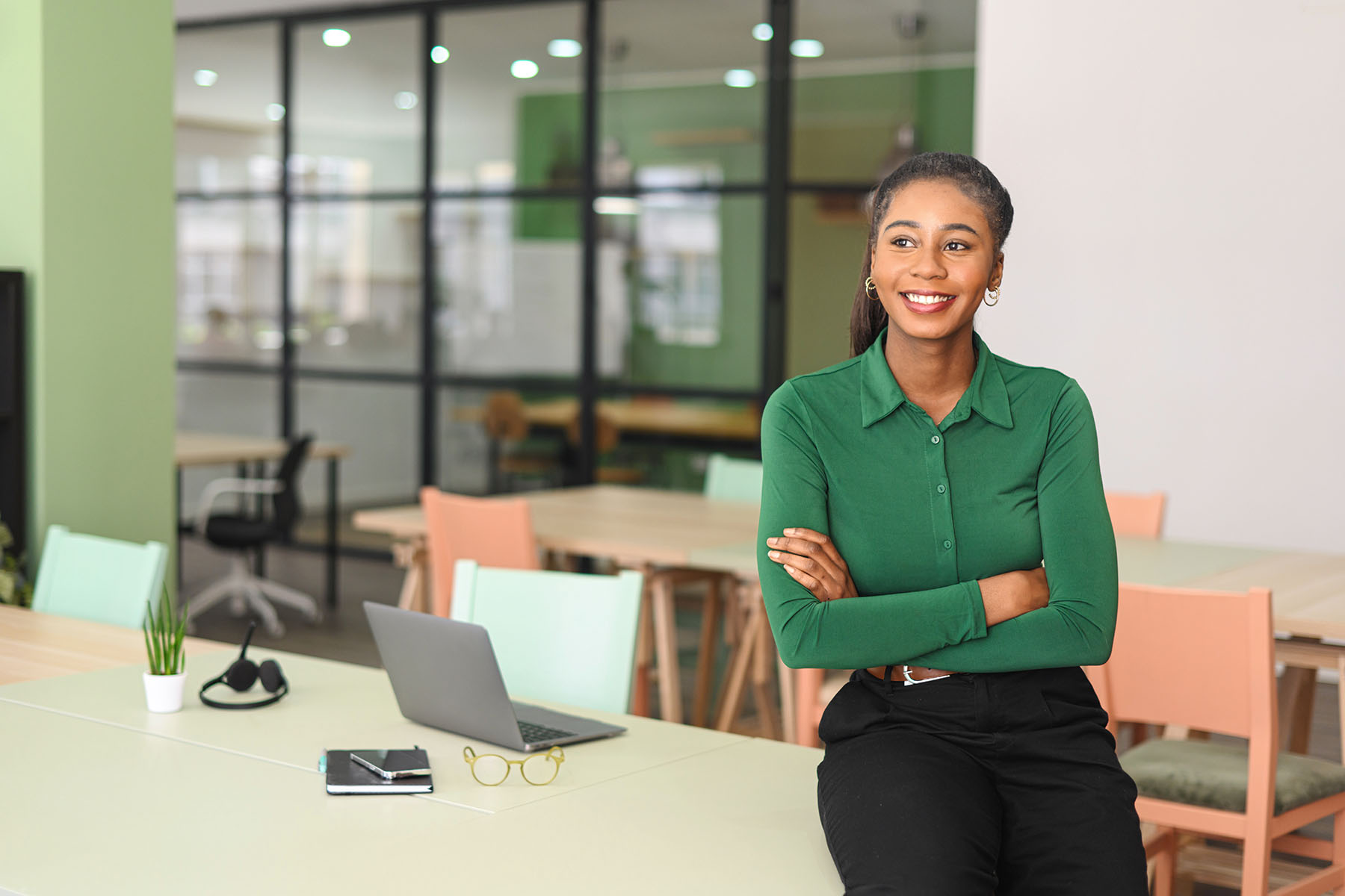 Successful young african-american female entrepreneur, small business owner, female office employee, black businesswoman wearing green casual shirt stands in confident pose